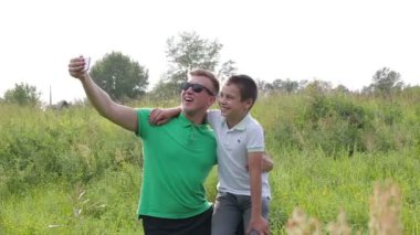 Mutlu baba ve oğul oynamak, kendini akıllı telefon kullanmak için resimleri