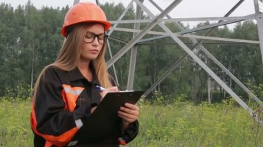 Bir elektrik alt istasyonlar saflara yakın, enerji hatları, ekip çalışması çalışan kadın mühendisi.
