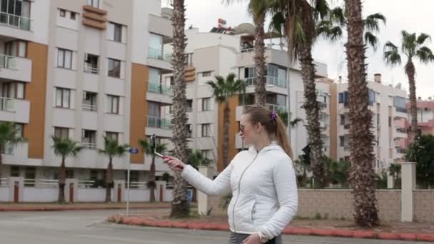 Mujer hermosa uso de teléfono inteligente monópodo hacer una foto — Vídeo de stock