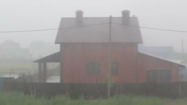 Проливной дождь льется на дом из красного кирпича — стоковое видео