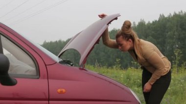 Kadın arabada yağ düzeyini denetler