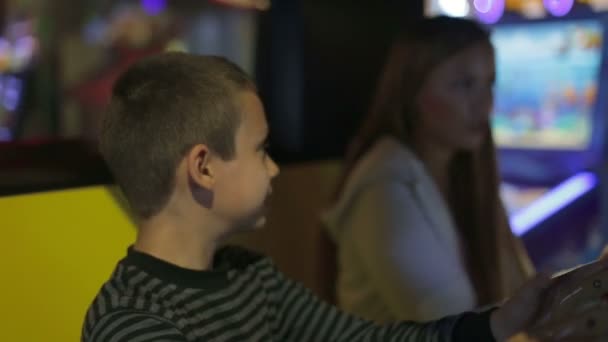 Ein Junge und ein Mädchen spielen ein Spiel auf dem Spielsimulator — Stockvideo