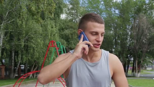 Lekkoatletycznego mężczyzna rozmowa korzystanie smartphone na świeżym powietrzu — Wideo stockowe