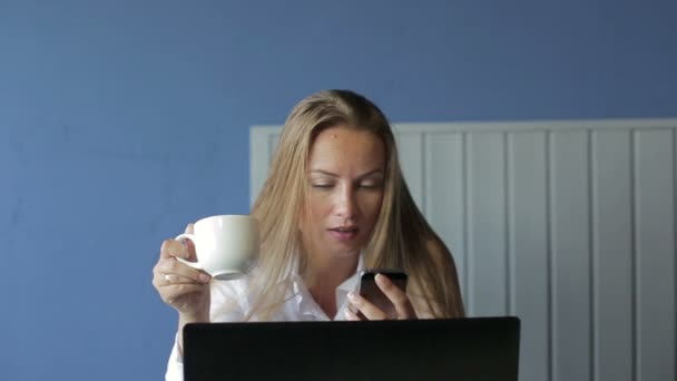 Forretningskvinne bruker smarttelefon, bruker bærbar PC – stockvideo