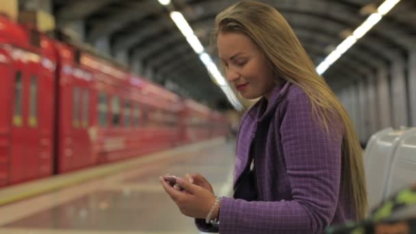 Young beautiful girl writes message use a smartphone — Stock Video