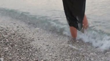 Akdeniz oldukça uzun kadın bacaklar kayaların üzerinde yıkar.