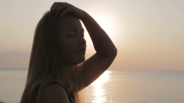 Mooi meisje geniet van de zee bij zonsondergang — Stockvideo