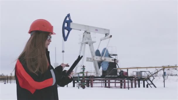 Um óleo de engenheiro feminino trabalhando no campo — Vídeo de Stock