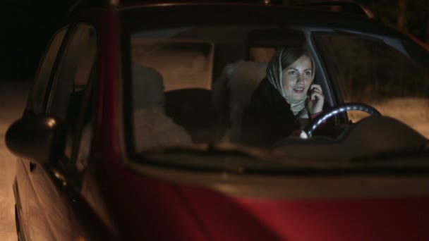 Europeisk kvinna talar med mobiltelefon när man sitter i bilen på förarsätet — Stockvideo