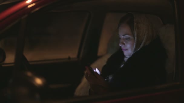 Mujer europea escribiendo teléfono móvil sentado en el coche en el asiento del conductor . — Vídeos de Stock