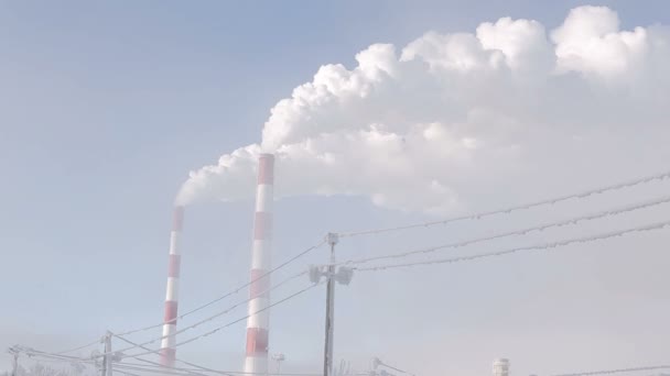 Bílý kouř od průmyslových komínů na světlém pozadí modré oblohy. — Stock video