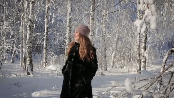 Una mujer hermosa es feliz y camina en el parque en un día de invierno . — Vídeos de Stock