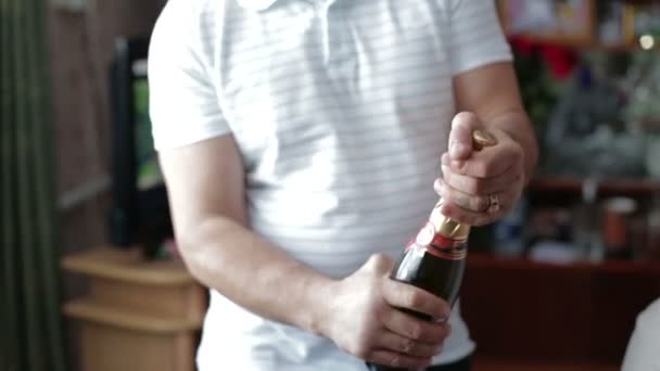 Närbild av en man öppnar en flaska champagne. — Stockvideo