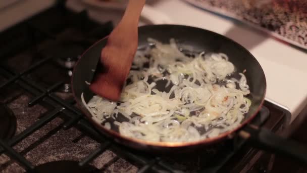 Händerna kvinna väcker lök till stekning i en stekpanna att laga middag — Stockvideo