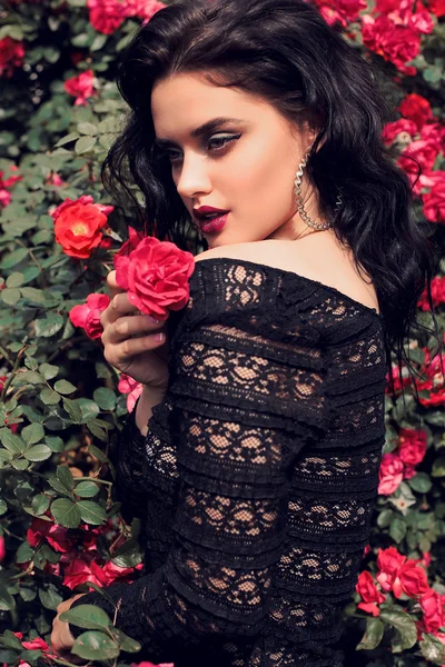 Mulher sensual posando ao lado de rosas — Fotografia de Stock