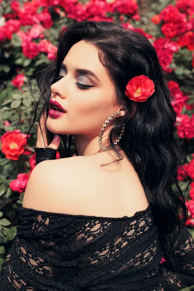 Güllerin yanında poz veren şehvetli kadın — Stok fotoğraf
