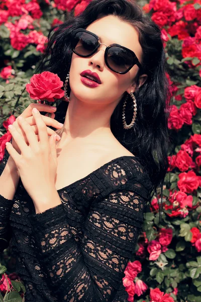 Güllerin yanında poz veren şehvetli kadın — Stok fotoğraf