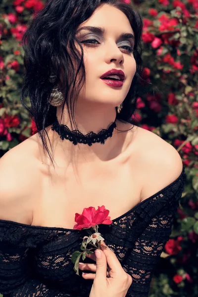 Чуттєва жінка позує біля троянд — стокове фото