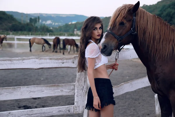 Vrouw poseren met zwarte paard — Stockfoto