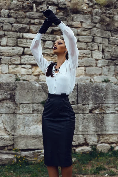 Elegante morena lleva camisa blanca, falda de cuero y guantes —  Fotos de Stock