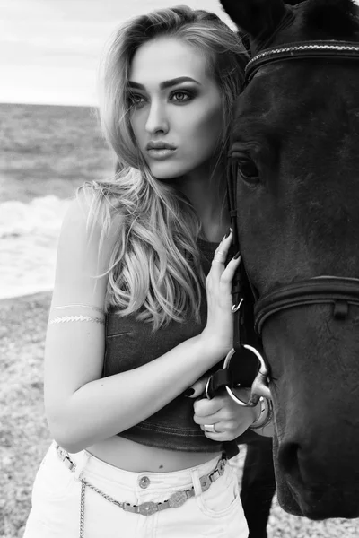 Mooie vrouw met zwarte paard — Stockfoto