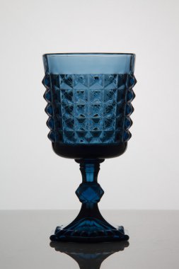 beyaz zemin üzerine mavi boş bardak