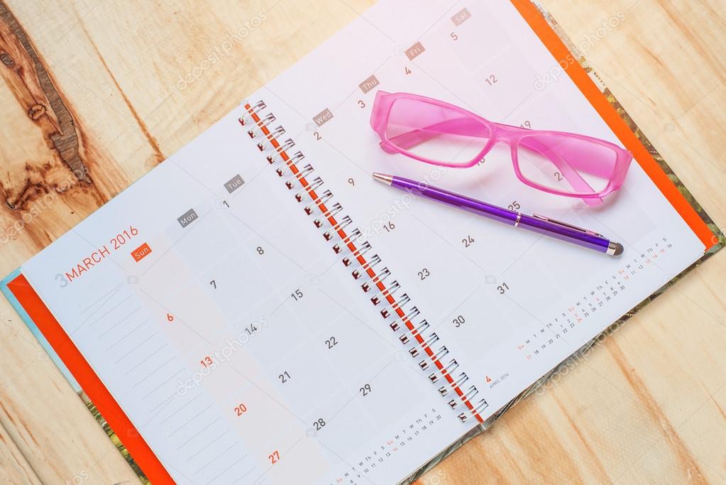 Pen with glasses on notebook calendar format