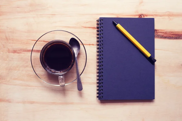 Kaffee und Notizbuch mit Stift auf Holz — Stockfoto