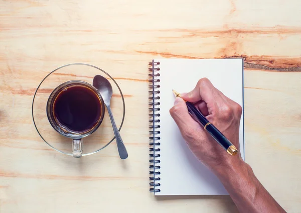 Beba café y escriba en el cuaderno — Foto de Stock