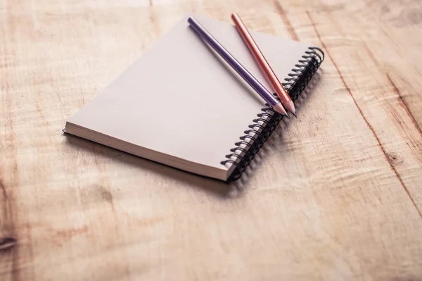 Cuaderno con lápices sobre mesa de madera —  Fotos de Stock