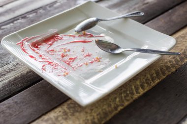 Beyaz kirli tabak kaşık ile ahşap arka plan üzerinde