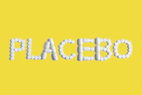 Placebo เป็นแนวคิดทางการแพทย์ในสีที่ทันสมัย แท็บเล็ตเรียงรายไปด้วยคําว่า PLACEBO.Ultimate Grey and Illuminating รูปภาพสต็อก