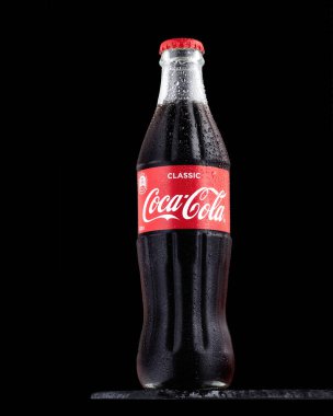 KAZAN, RUSSIA - 7 Nisan 2021: Siyah bir arkaplana karşı, cam sisli bir şişedeki buğulama damlalarıyla kaplı Coca-Cola