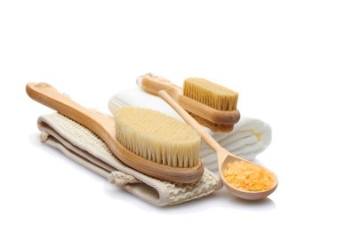 Vücut bakımı için kullanılan doğal malzemelerden oluşan bir set beyaz arka planda izole edilmiş. Kuru masaj fırçası, bez, sünger taşı ve banyo tuzu. Kişisel bakım kavramı