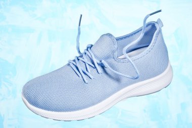 Mavi arka planda Tekstil 'den kadın ayakkabıları. Hareket ve hafiflik kavramı