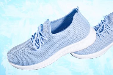 Mavi arka planda Tekstil 'den kadın ayakkabıları. Hareket ve hafiflik kavramı