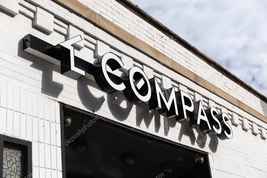 Chicago, IL, USA - October 16, 2025: The Compass Real Estate logo on a white brick office building in downtown Chicago, IL.