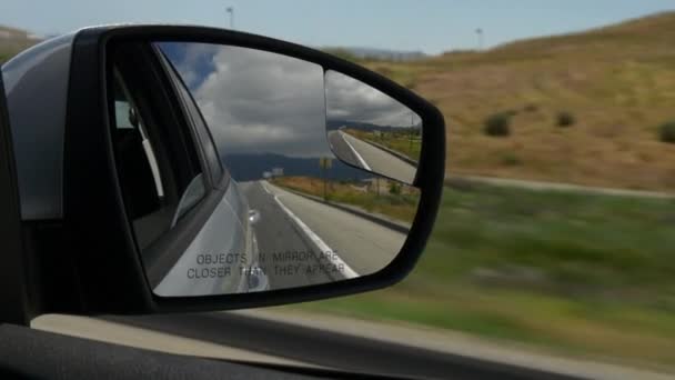 Weg in de rearview spiegel van een auto — Stockvideo