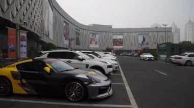 Gündüz vakti Qingdao şehri ünlü lüks alışveriş merkezinin önünde park panoraması 4k Çin