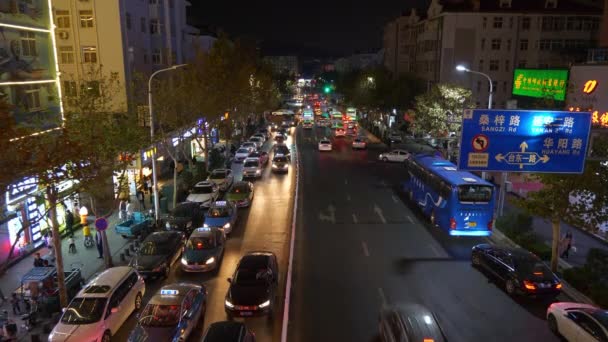 Night time illuminated Qingdao city with street traffic 