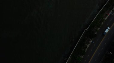 Aerial topdown view of Sanya riverside street traffic, Hainan island, China, 4k 