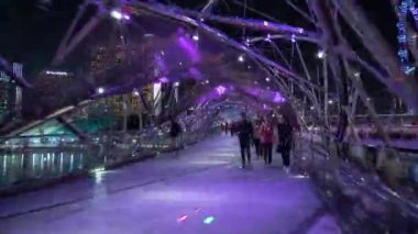 Gece aydınlatılmış Singapur şehir merkezi ünlü yaya köprüsü zaman çizelgesi panorama 4k