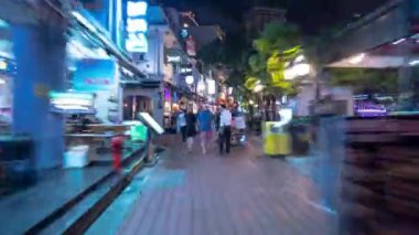 Gece vakti aydınlatılmış Singapur şehir merkezi kalabalık restoran caddesi yürüyüş zamanı panorama 4k