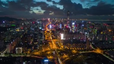 Günbatımı gecesi ünlü Shenzhen şehri trafik yolu kavşağı havadan panoramik 4k eğik vardiya zamanı Çin porselenlerini aydınlattı