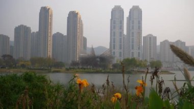 Sunset Changsha Şehir Parkı Modern Sanat Anıtı Göl kenarındaki apartman kompleksi ağır çekim panorama 4k porselen