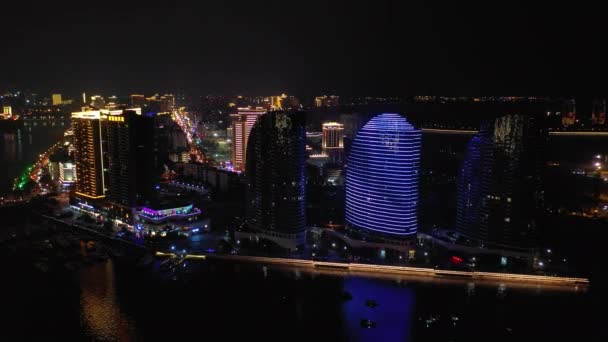 夜の空中パノラマは 三亜湾 海南島 4Kで川沿いのアパート複合照明 — ストック動画