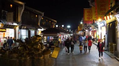 HANGZHOU, ÇİN - CIRCA 2019: İnsanlar geceleyin yayaların önünden yürüyorlar, Hangzhou
