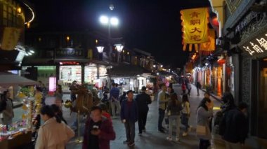 HANGZHOU, ÇİN - CIRCA 2019: İnsanlar geceleyin yayaların önünden yürüyorlar, Hangzhou