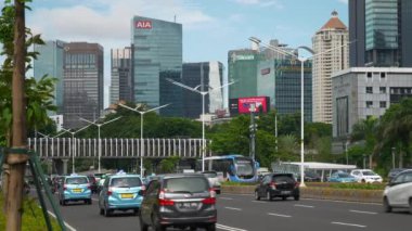 Güneşli bir gün jakarta şehir merkezi trafik sokağı şehir merkezi yavaş çekim panorama 4k Endonezya