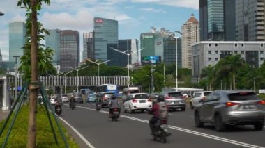 Güneşli bir gün jakarta şehir merkezi trafik sokağı şehir merkezi yavaş çekim panorama 4k Endonezya